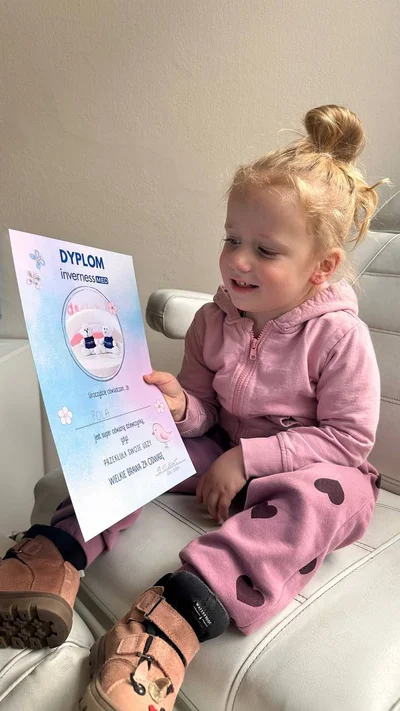 Zadowolone dziecko z dyplomem Inverness MED po przekłuciu uszu